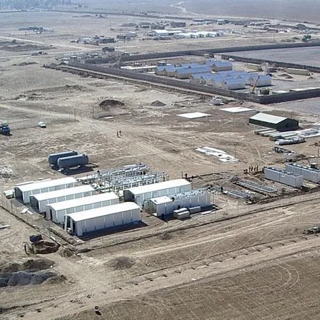 Aerial view of a military base with rows of tents and vehicles