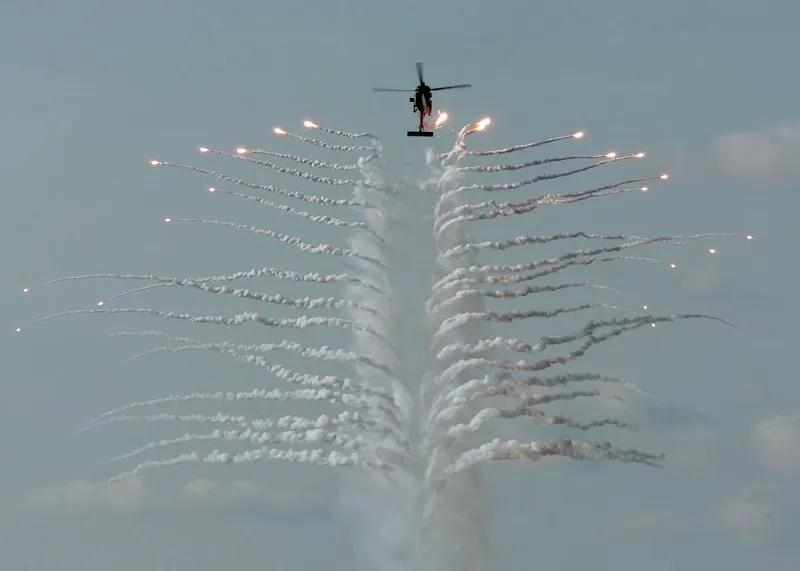 Military helicopter releasing countermeasure flares